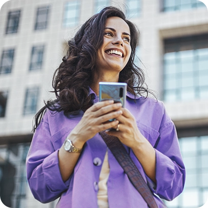 Imagem de uma mulher sorrindo enquanto segura um celular