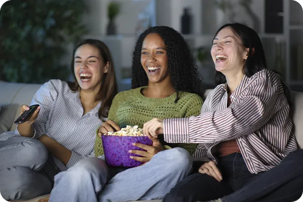 Grupo reunido no sofá assistindo programação por streaming na televisão.