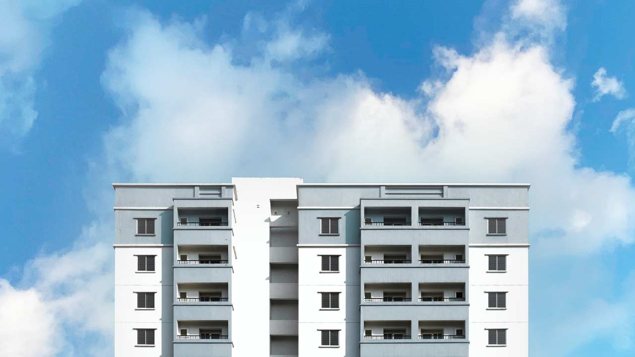 Imagem de um prédio. Ao fundo, um céu azul.