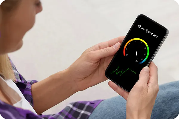 Pessoa segurando celular com medidor de velocidade de conexão na tela.
