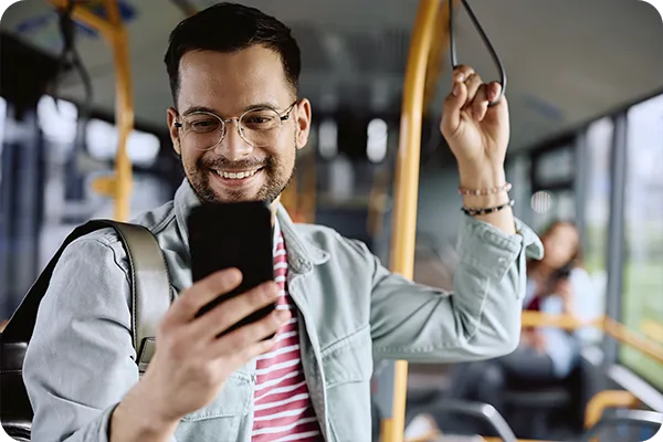 Pessoa usando smartphone dentro de transporte coletivo.