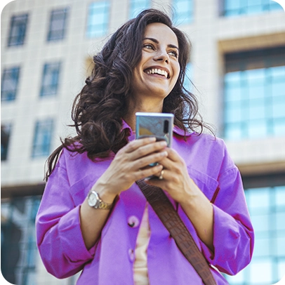 Imagem de uma mulher sorrindo enquanto segura um celular