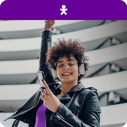 Mulher de jaqueta preta e fones, segurando celular