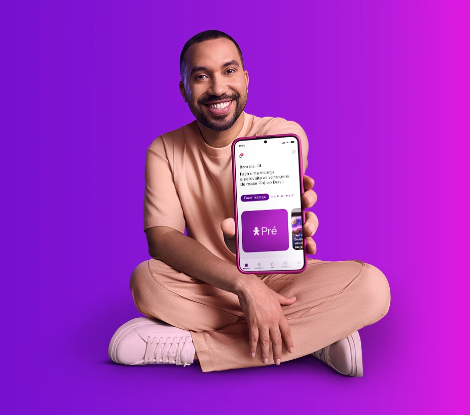 Imagem do Gil do Vigor sentado mostrando no celular o App Vivo