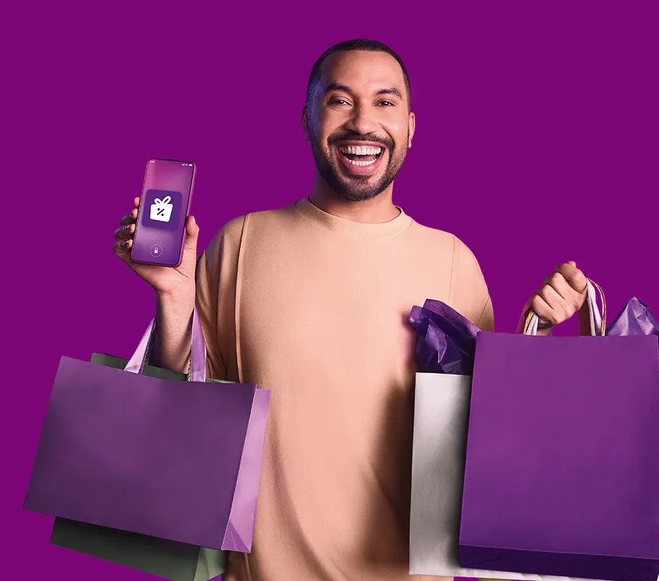 Imagem de um homem, Gil do vigor,  segurando um celular com logo do Vale Bonus.