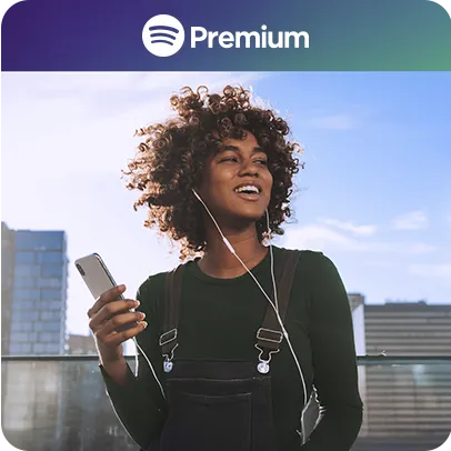 Imagem de uma mulher sorrindo com fone de ouvido e um celular na mão