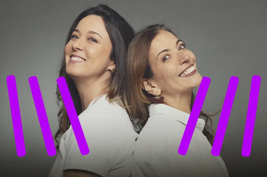 Duas mulheres de costas uma para outra sorrindo