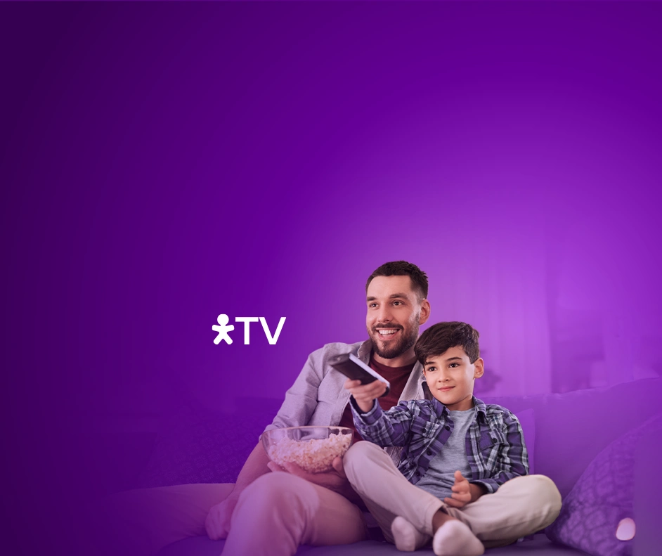 Pai e filho assistindo TV com pipoca e controle remoto em mãos e logo Vivo TV.