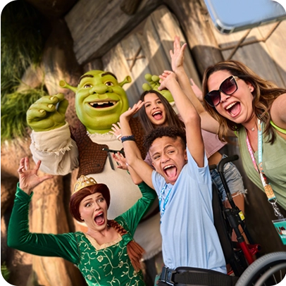 Pessoas posam ao lado dos personagens Shrek e Fiona em parque temático.