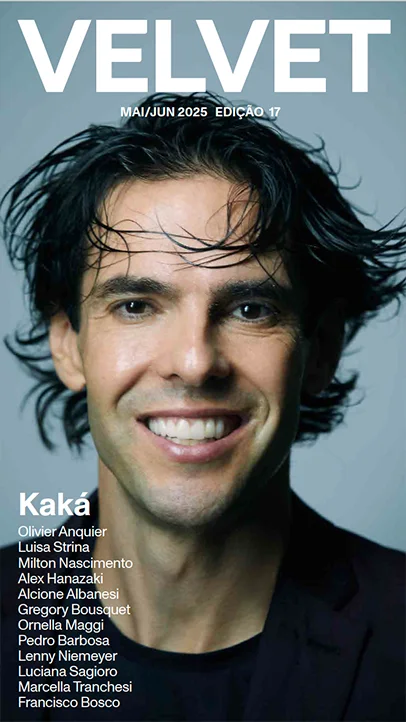 Foto com close no rosto de um homem, sorrindo, cabelos escuros e tamanho médio.