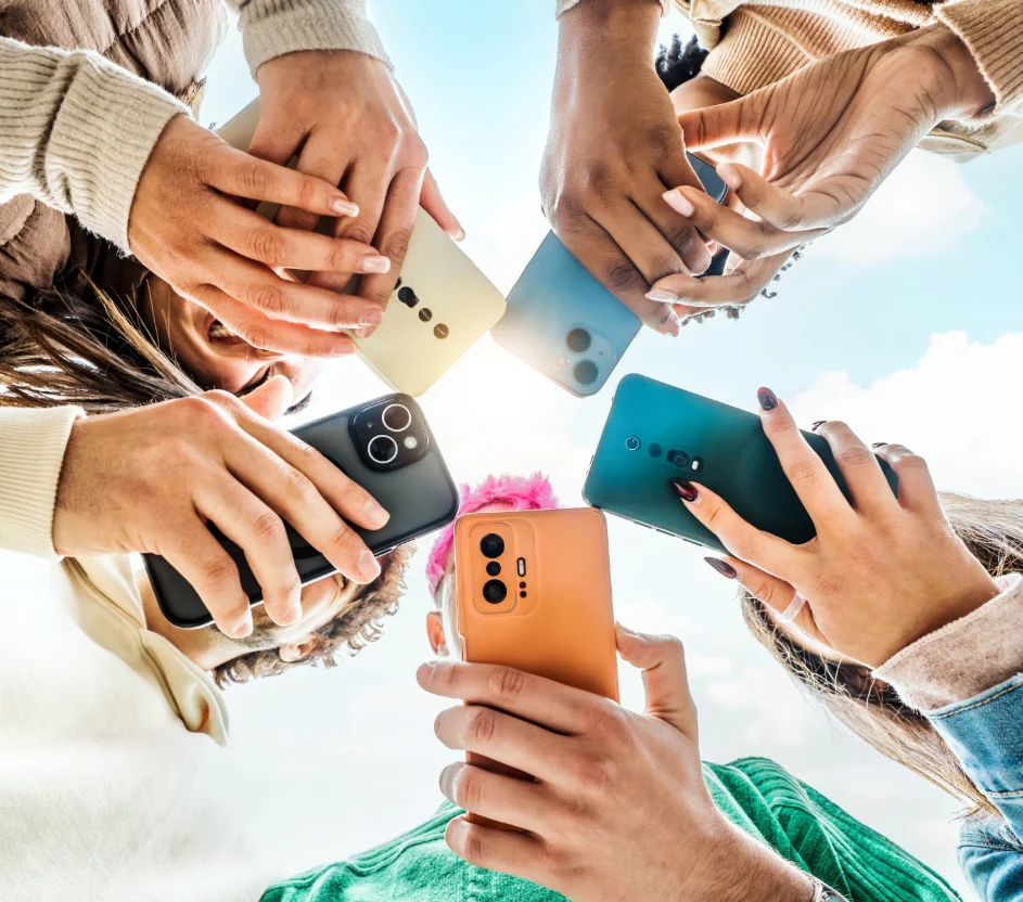Pessoas mexendo no celular com foco na mão