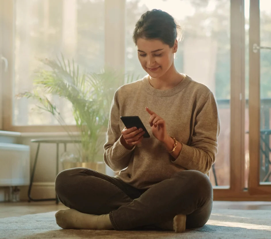 Pessoa sozinha mexendo no celular sorridente 