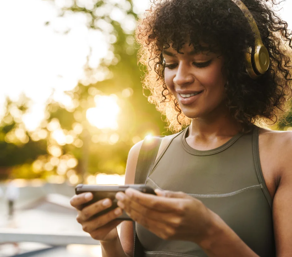 Mulher usando fone de ouvido e olhando para o celular