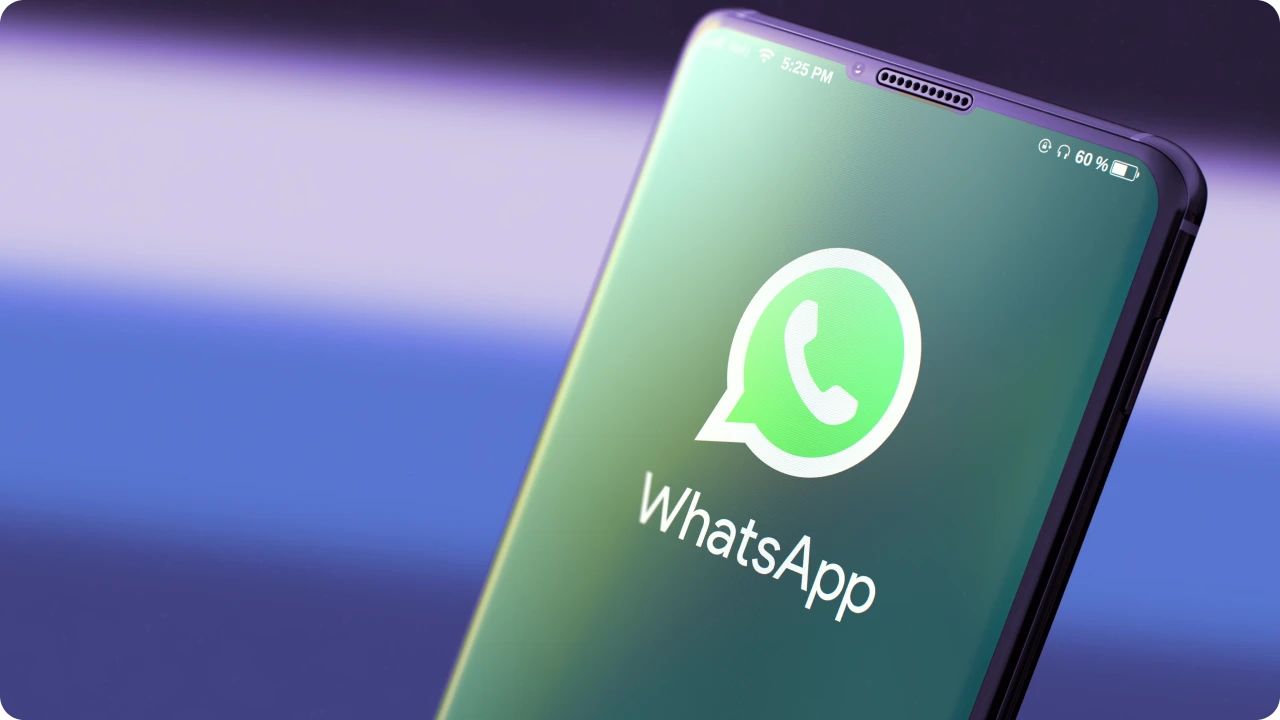 Smartphone com logotipo do WhatsApp em destaque sobre fundo azul.