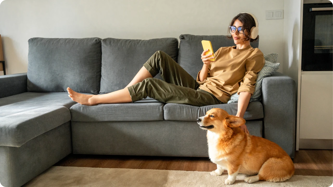 Pessoa utiliza smartphone em casa enquanto acessa serviços online.