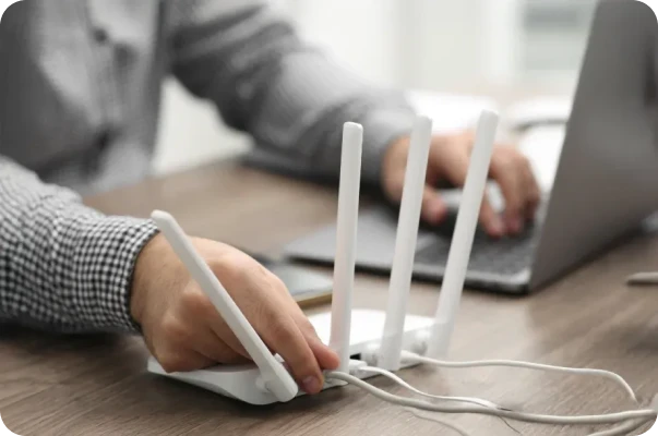Pessoa ajusta roteador Wi‑Fi para configurar conexão de internet.