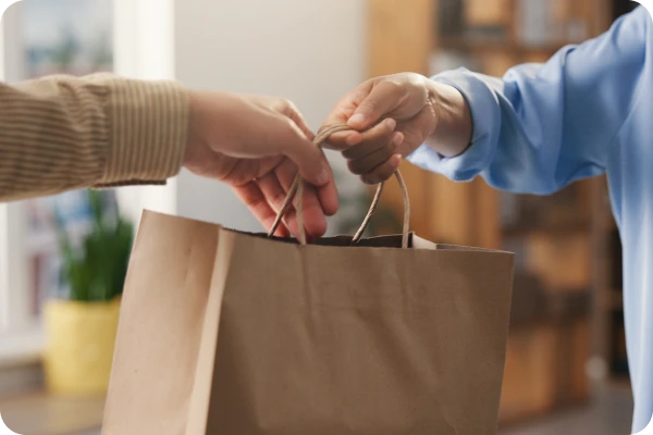 Entrega de sacola de compras durante aquisição de produto eletrônico.
