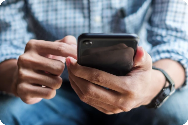 Pessoa utiliza smartphone para verificar informações em aplicativo móvel.