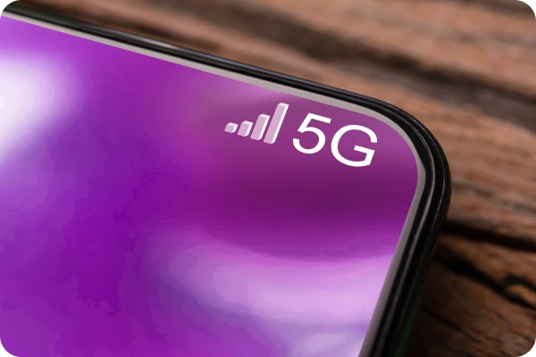  Detalhe de celular conectado à rede 5G sobre superfície de madeira.