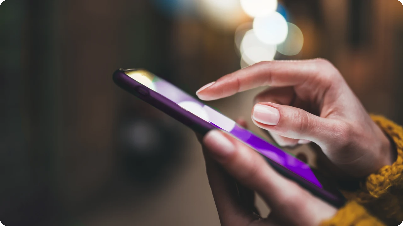 Mão interage com tela de celular durante navegação em rede móvel.