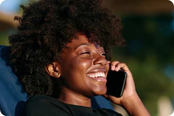 Pessoa segura smartphone junto ao ouvido enquanto realiza uma ligação.
