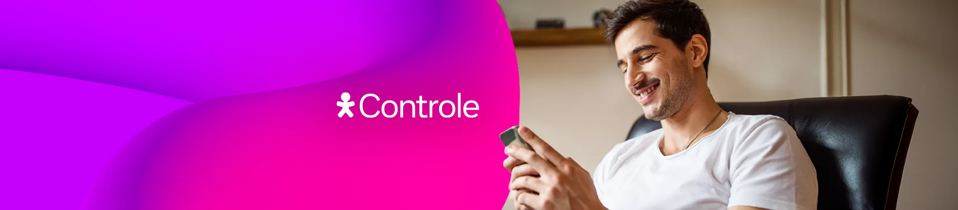 Homem sentado, olhando para um celular em mãos.