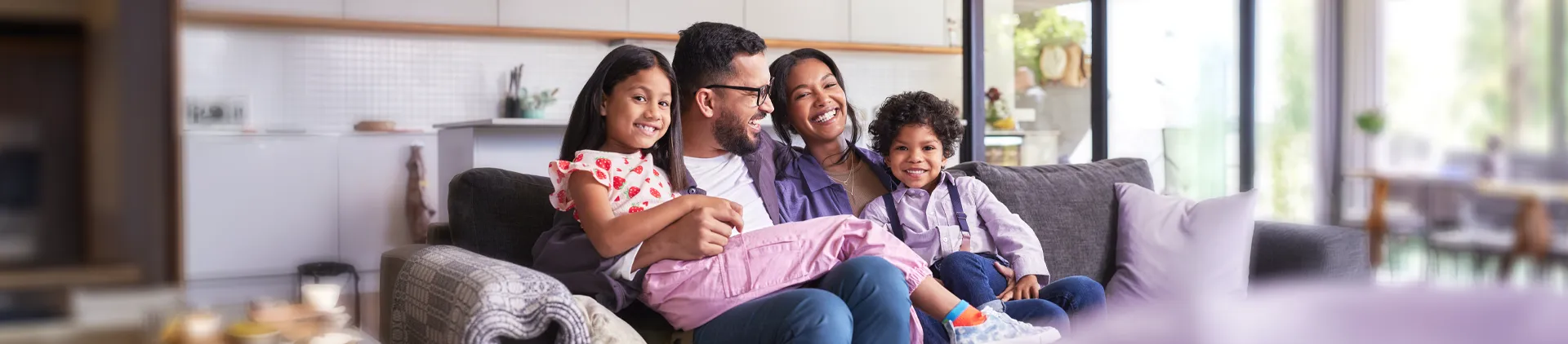 Imagem de um uma família sentada em um sofá.