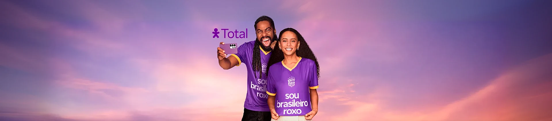 Imagem do casal, Thais Araújo e Lazaro Ramos, com uma camisa roxa, sorrindo e comemorando.