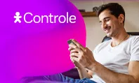 Homem sentado, olhando para um celular em mãos.