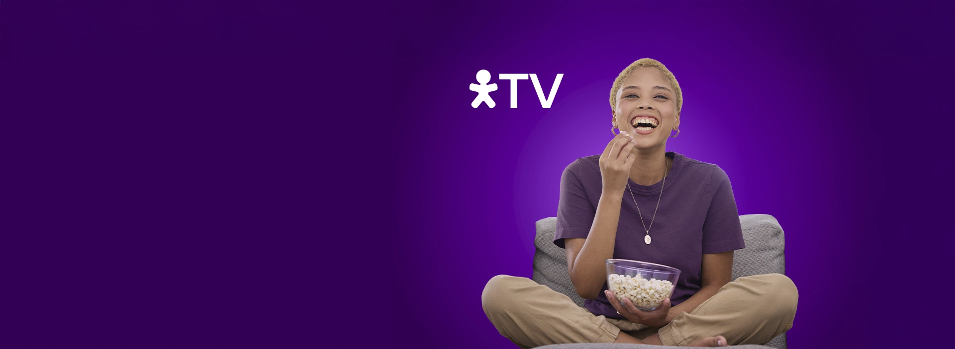 Mulher sentada comendo pipoca com logo Vivo TV.