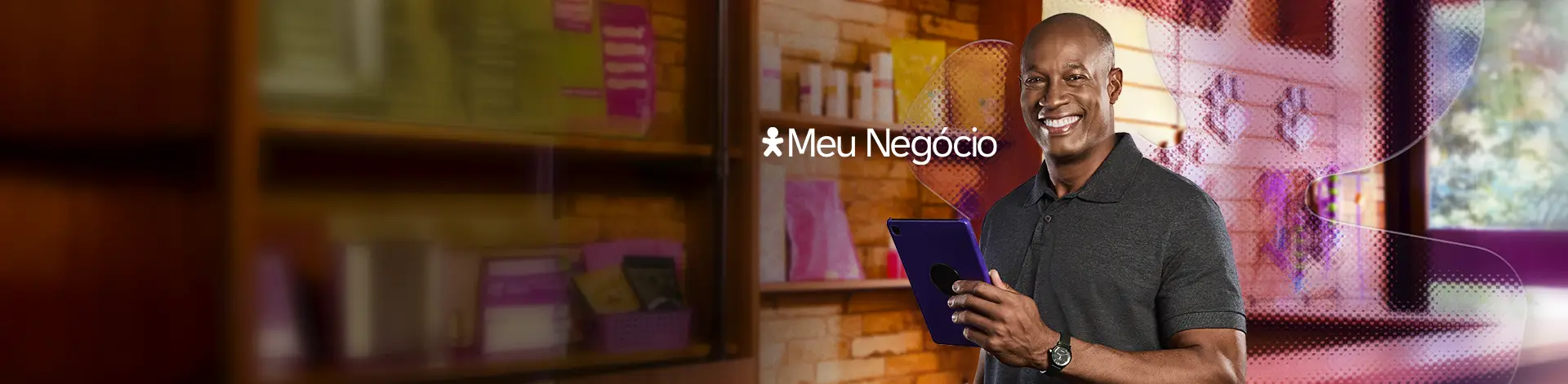Homem sorrindo com um tablet na mão no fundo de uma parede de uma petshop e o Vivinho atrás.
