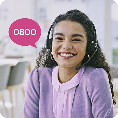 Mulher sorrindo, fones com microfone, usando roupas roxas, cabelo longo e enrolado.
