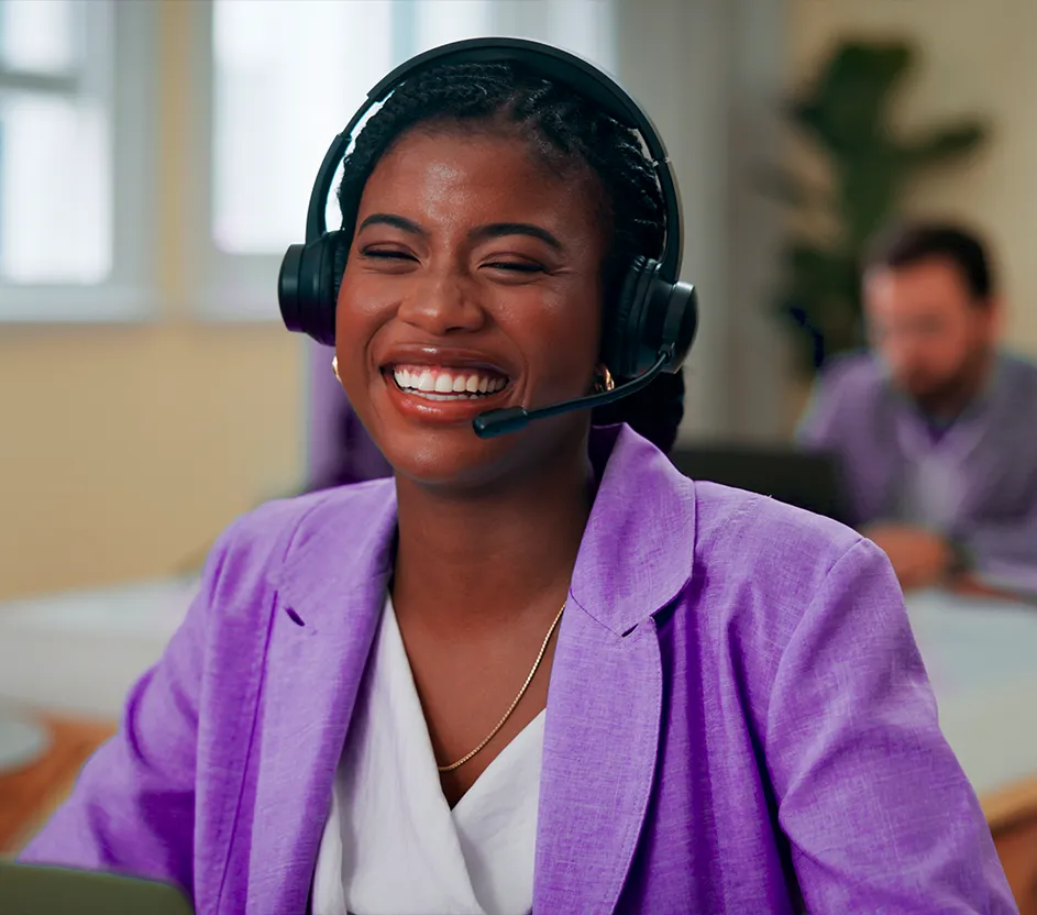 Imagem de uma mulher sorrindo enquanto faz atendimento com fones de ouvido