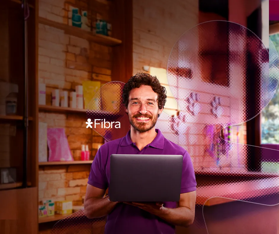 Imagem de um homem com camiseta roxa segurando um computador. Logo Vivo Fibra