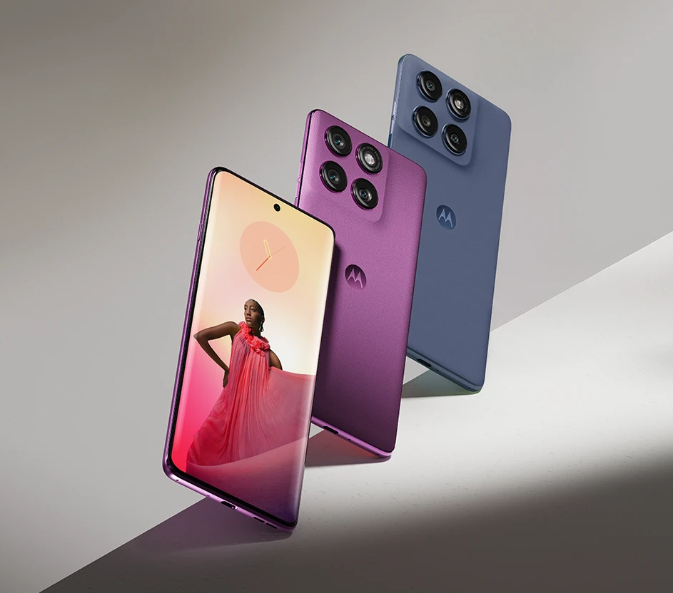 Três smartphones Motorola lado a lado, dois rosas e um roxo.