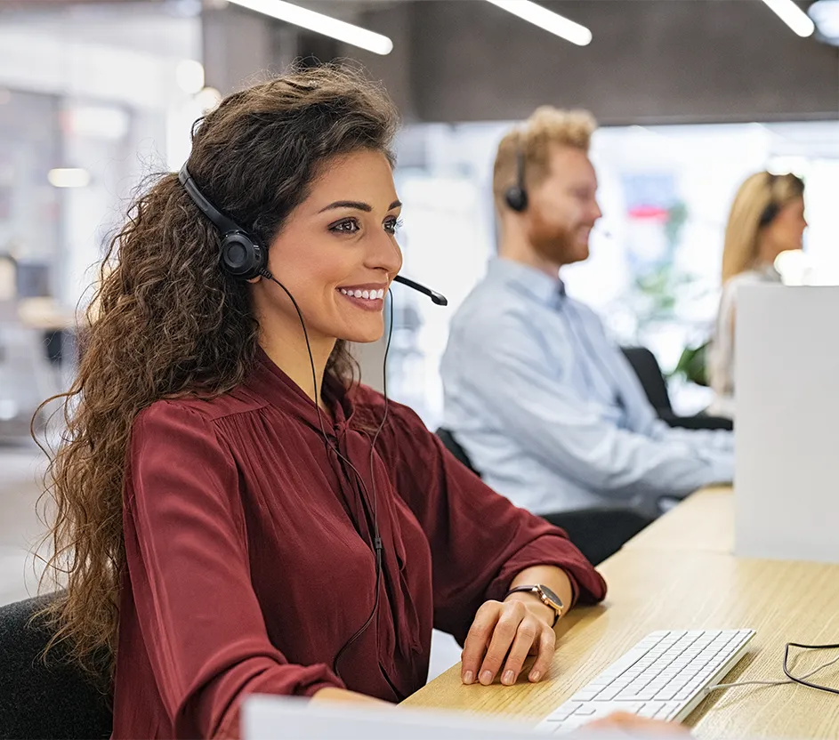 Imagem de pessoas sentadas num escritório enquanto fazem atendimentos por telefone.