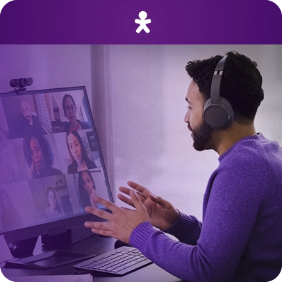 Imagem de uma pessoa com fone de ouvido sentada no computador em uma reunião virtual