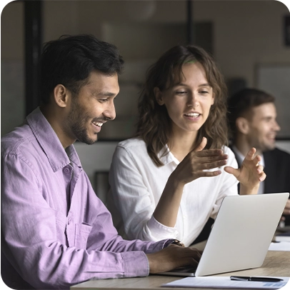 Imagem de duas pessoas conversando enquanto olham para um notebook
