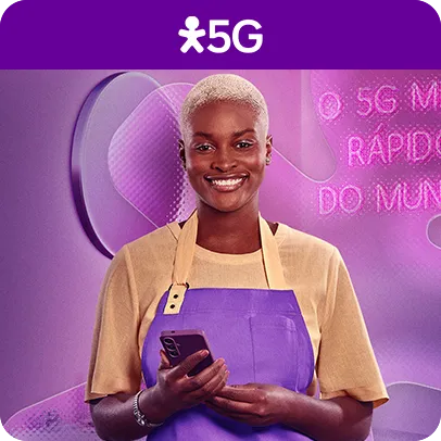 Imagem de uma mulher olhando para frente sorrindo com um celular na mão e com um avental roxo
