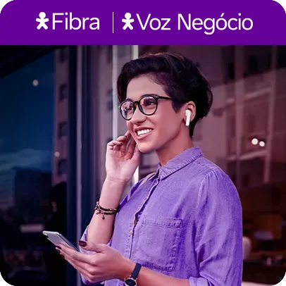 Imagem de uma mulher com fones de ouvido e celular nas mãos.