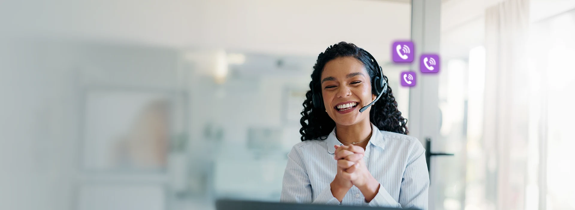 Imagem de uma mulher sorrindo com um microfone no rosto e balões com símbolo de telefone.