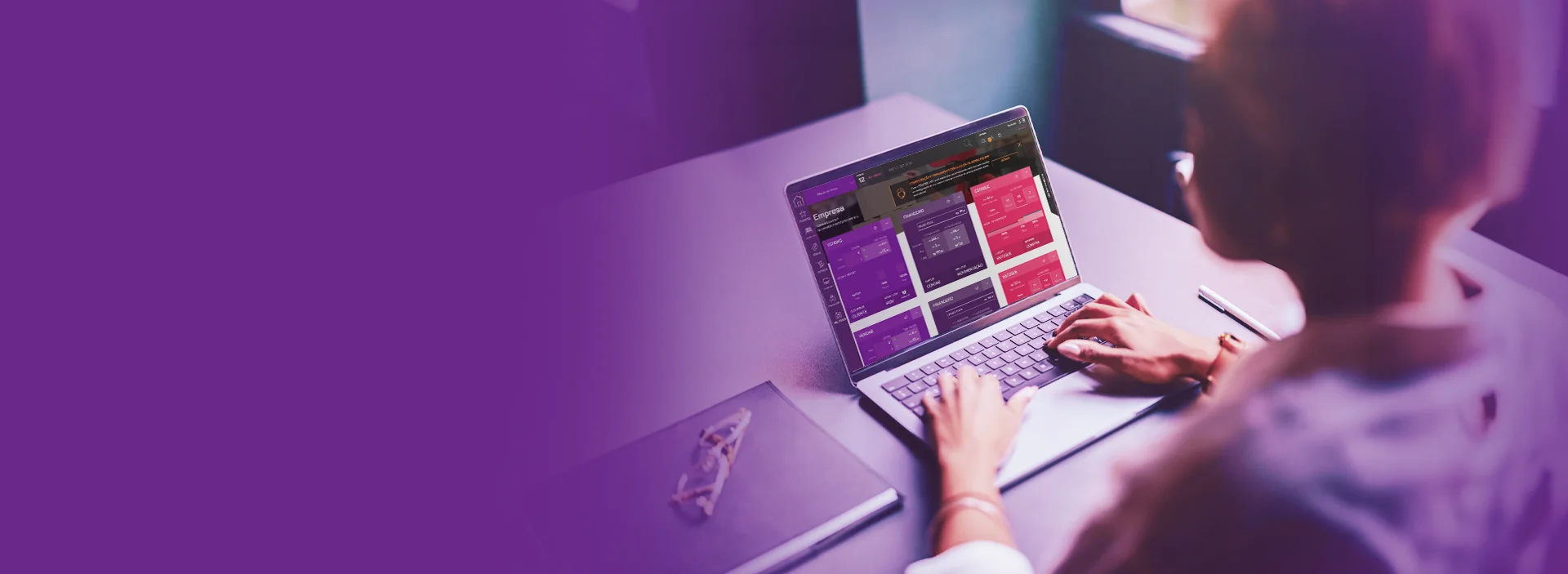 Foto de uma mulher usando o notebook, com foco na tela.