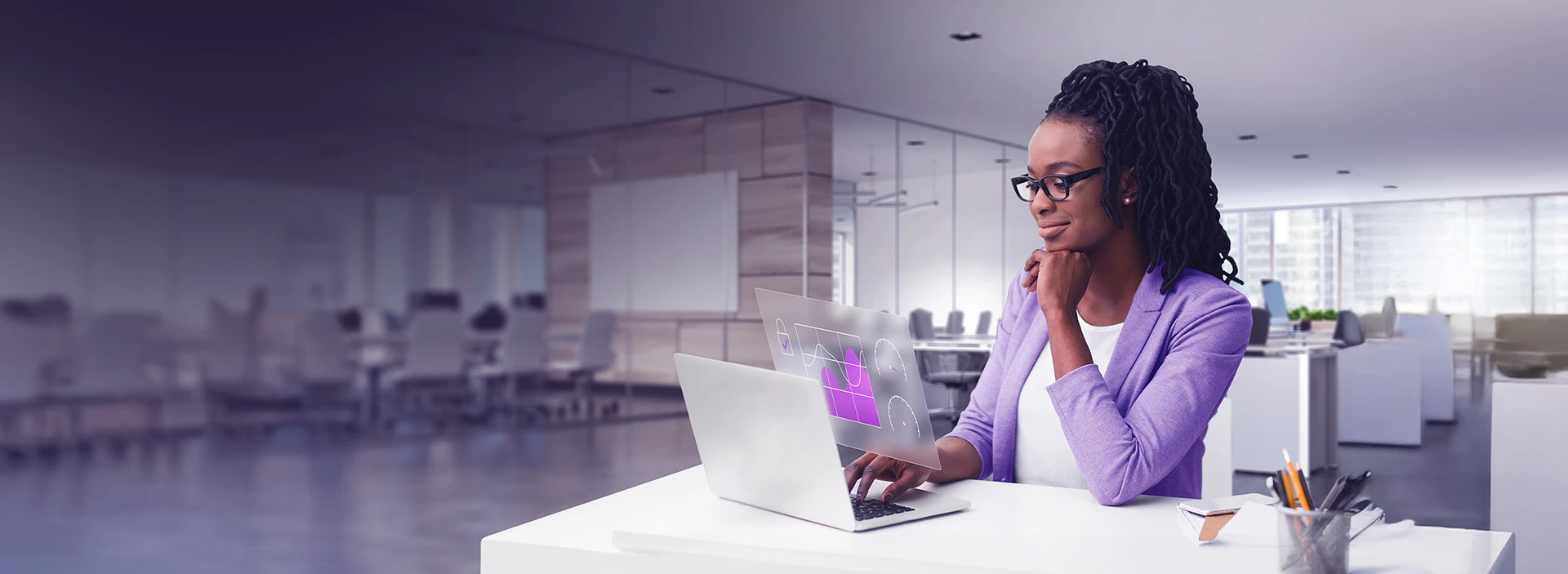 Imagem d euma mulher no escritório, em frente ao notebook.