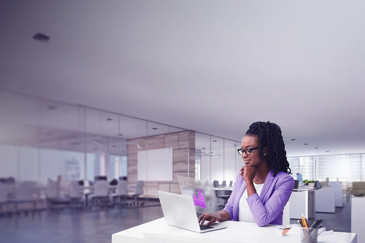 Imagem d euma mulher no escritório, em frente ao notebook.